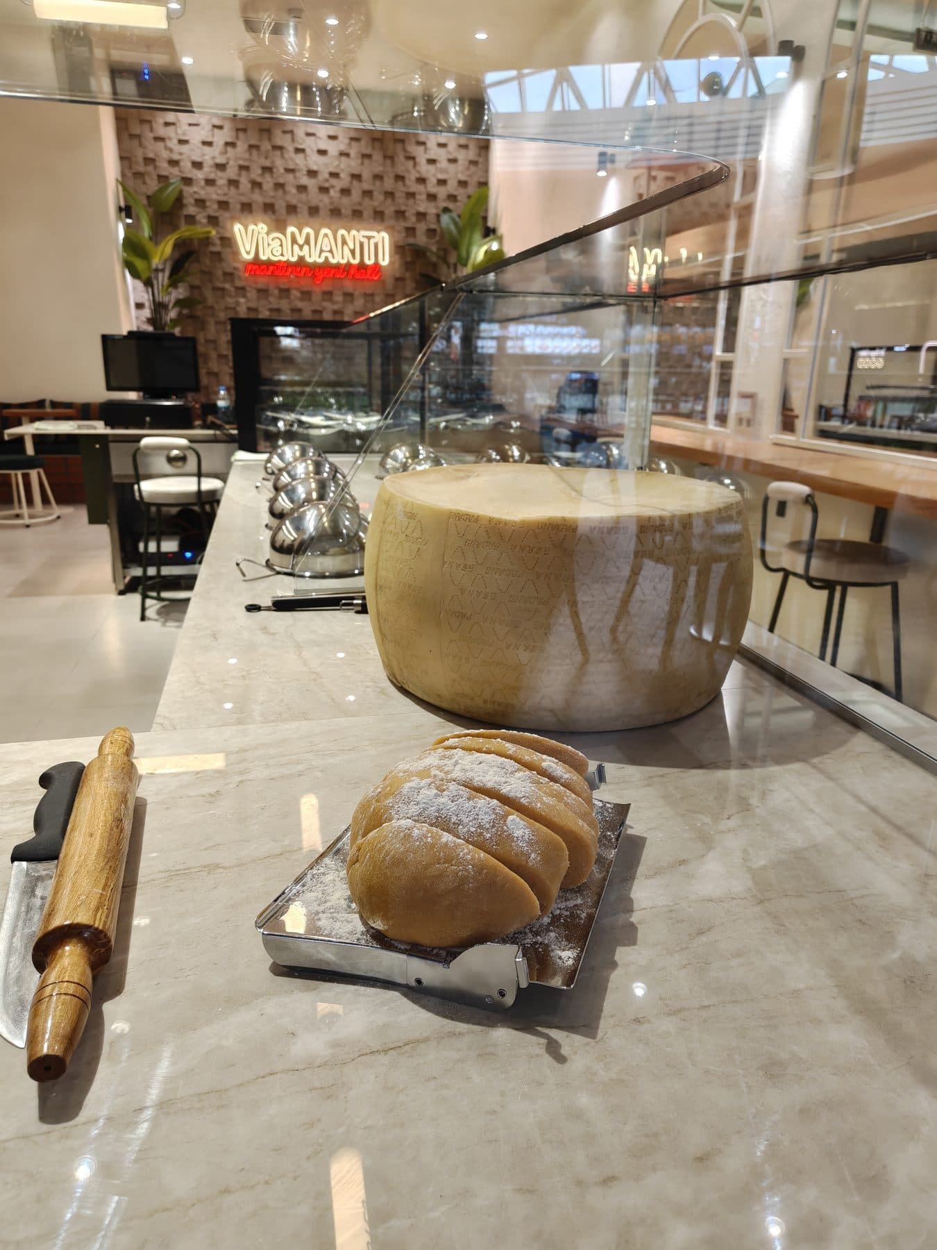 Tezgâhta parmesan tekeri, hamur ve oklava