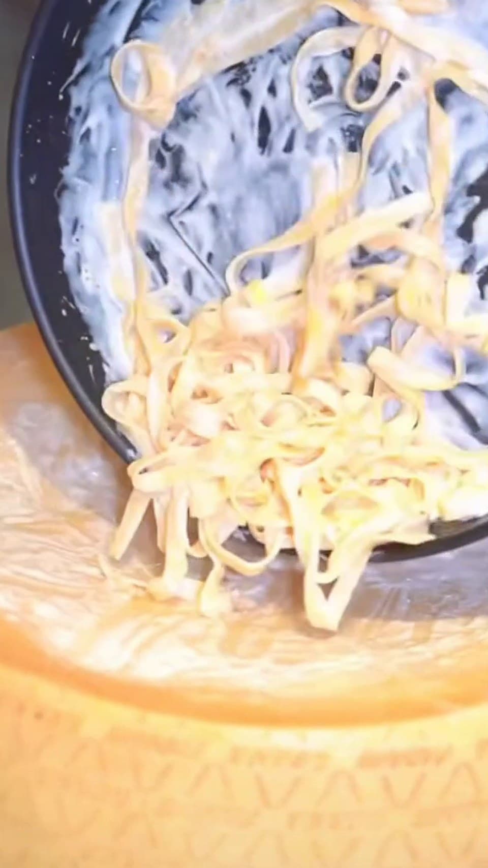 Parmesan tekerine dökülen kremalı fettuccine